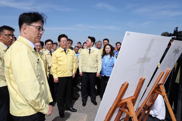 이재명 대통령이 18일 전남 무안국제공항 제주항공 참사 유해 수습현장에서 진행상황 설명을 듣고 있다. [청와대통신사진기자단] 연합뉴스
