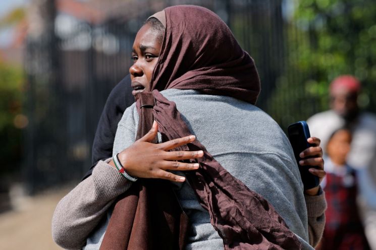 On the 18th (local time), women are embracing each other waiting for children coming out of the mosque at a gathering spot near the scene of the shooting incident at the Islamic Center in San Diego, California, USA. Photo by Reuters, Yonhap News Agency