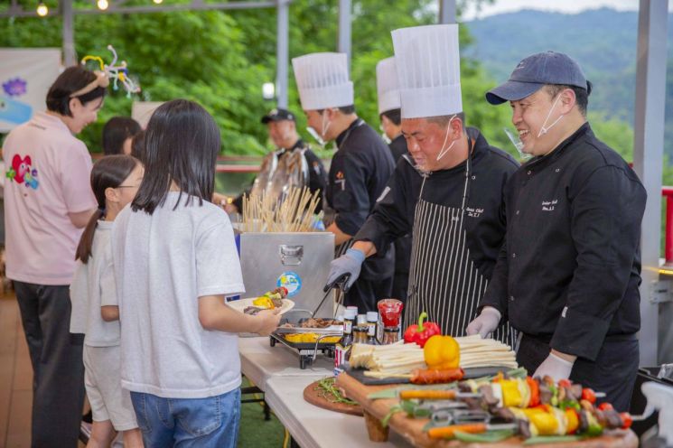 임직원 봉사단이 아이들과 이야기 나누고 있다. 아워홈 제공.