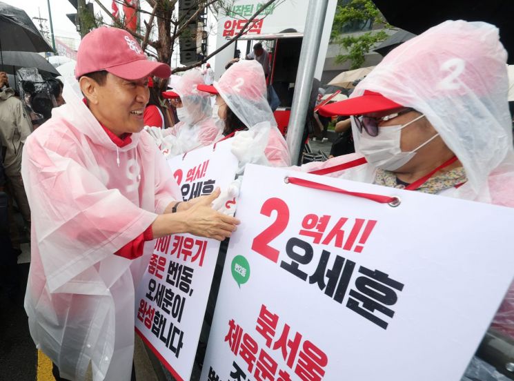오세훈 국민의힘 서울시장 후보가 공식 선거운동 첫날인 21일 서울 강북구 삼양사거리에서 열린 첫 유세에서 선거운동원들과 악수를 하고 있다. 연합뉴스