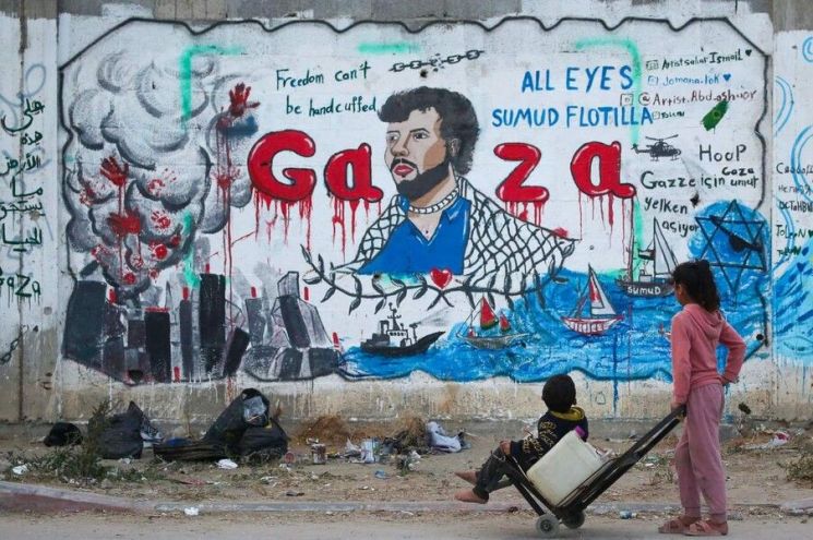 A boy in the Nuseirat area of central Gaza Strip, Palestine, is looking at a mural depicting the Israeli army blocking the Gaza Strip relief convoy "Global Sumud Fleet" on the 19th (local time). Photo by AFP Yonhap News