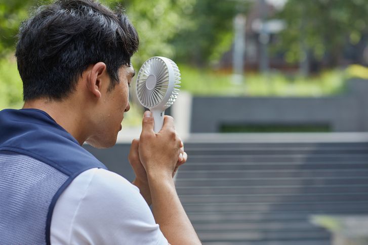 한 남성이 더위를 식히기 위해 휴대용 선풍기를 사용하고 있다. 게티이미지코리아