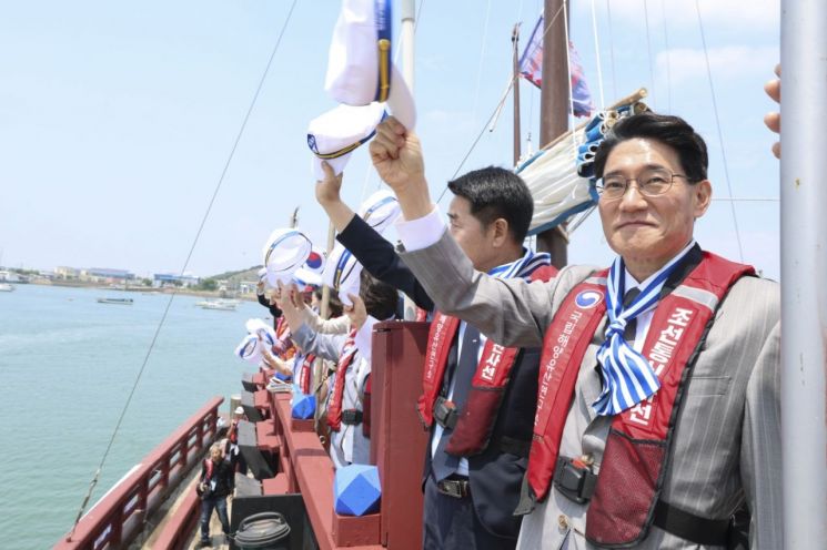 전곡항 앞바다를 순항하는 조선통신사선 선상에서 윤성진 화성특례시장 권한대행과 시민 탑승객들이 환영하는 관람객들을 향해 모자를 흔들며 화답하고 있다. 화성시 제공