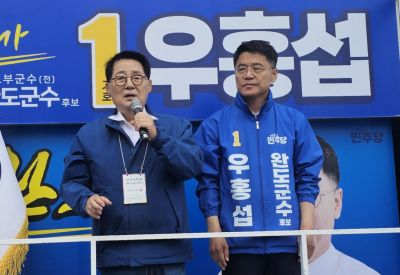 유세 현장에서 박지원 의원이 우홍섭 완도군수 후보와 함께 단상에 올라 응원하고 있다. 이준경 기자