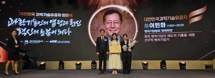 The bereaved family of the late Min-Hwa Lee, Honorary Chairman of the Korea Venture Business Association, is taking a commemorative photo with Byung-Hoon Bae, Minister of Science and ICT (Deputy Prime Minister), after receiving the Certificate and Nameplate of Scientific and Technological Merit. Korea Venture Business Association