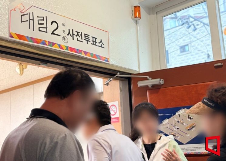 29일 오전 서울 영등포구 대림2동주민센터에서 첫 번째로 사전투표에 참여한 김모씨(58·가운데)가 투표소로 입장하고 있다. 이지예 기자