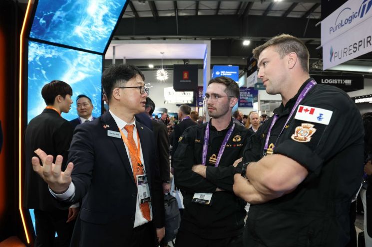 캐나다 오타와에서 열린 'CANSEC 2026' 전시회 내 한화오션 부스에서 한화오션 관계자가 방문객들에게 최신예 잠수함 모델을 소개하고 있다.