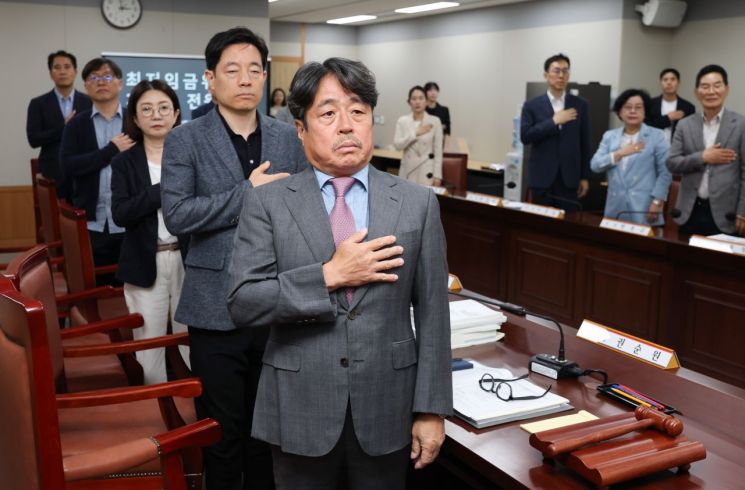 4일 정부세종청사 최저임금위원회에서 열린 제3차 전원회의에서 권순원 위원장과 위원들이 국기에 경례하고 있다. 연합뉴스