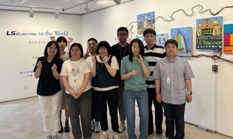 LS일렉트릭이 오는 6일까지 서울 종로구 이음갤러리에서 발달장애 예술인 미술단 ‘그린 캔버스’의 첫 전시회 '전기가 흐르는 사이(Where Electricity Flows)'를 개최한다고 밝혔다. 사진은 그린캔버스 단원들이 전시회에서 기념사진을 촬영하는 모습. LS일렉트릭