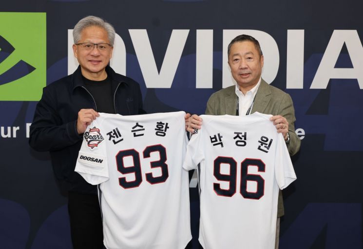 박정원 두산그룹 회장과 젠슨 황 엔비디아 최고경영자가 7일 잠실야구경기장에서 자신의 이름이 적힌 유니폼을 교환하며 기념촬영하고 있다. 두산그룹