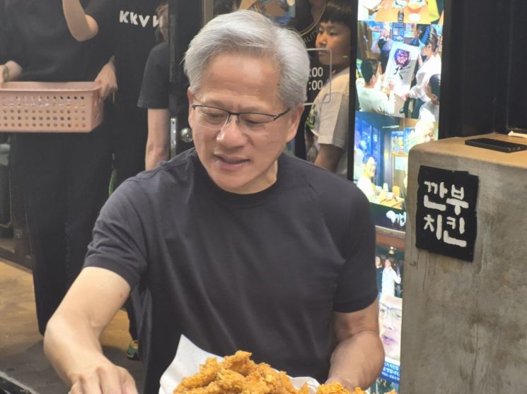 7일 오후 젠슨 황 엔비디아 최고경영자가 깐부치킨 삼성점 밖으로 나와 거리에 나온 시민들에게 치킨을 나눠주고 있다. 김진영 기자