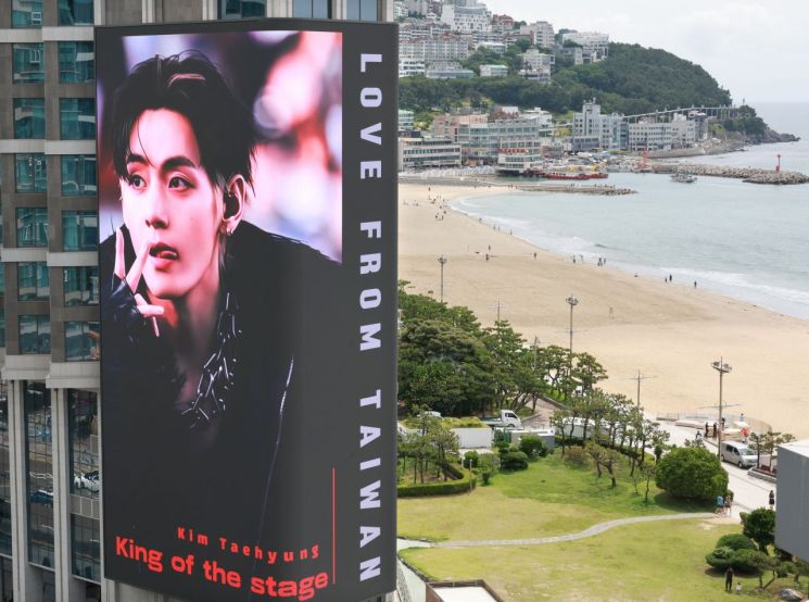 BTS의 공연을 앞두고 9일 부산 해운대해수욕장 앞 그랜드조선 호텔 외벽에 설치된 초대형 미디어 전광판에 방탄소년단(BTS) 뷔 사진이 송출되고 있다. 연합뉴스