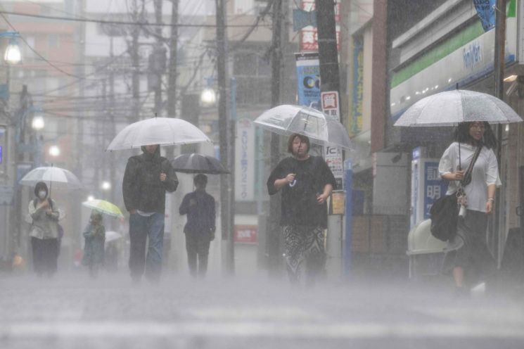 강한 열대성 폭풍 장미의 영향으로 폭우가 내린 3일 일본 가나가와현 가와사키에서 시민들이 우산을 쓴 채 출근하고 있다. AFP연합뉴스