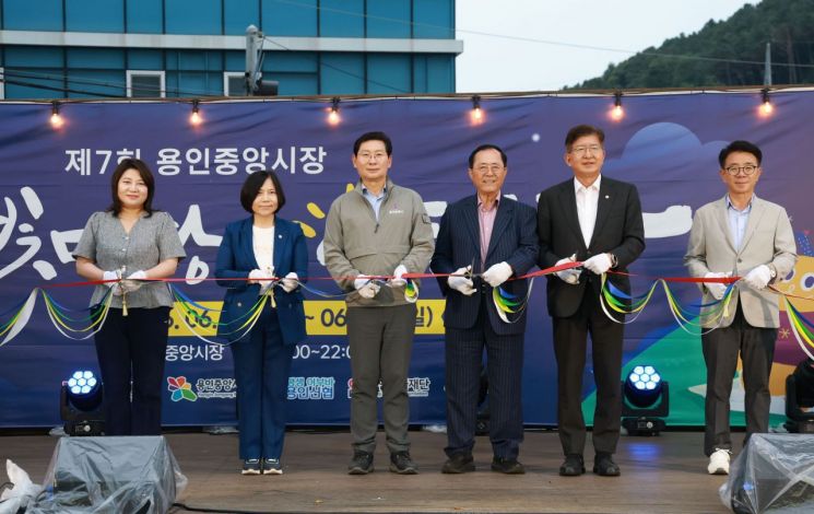 지난 19일 용인중앙시장에서 이상일 시장(왼쪽 세 번째)과 별빛마당 야시장 참석자들이 기념 테이프를 자르고 있다. 용인시 제공