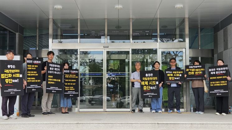국립창원대학교 교수회가 제1학생회관(봉림관) 입구에서 손팻말 시위를 벌이고 있다. [사진=이세령 기자]