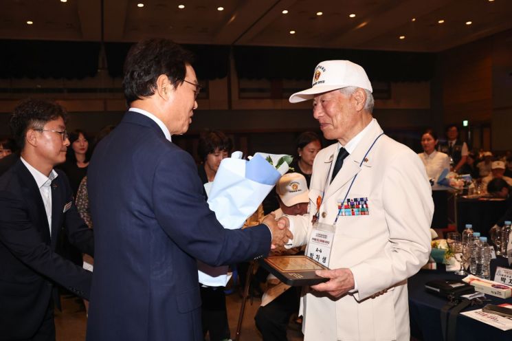 박완수 경남도지사(왼쪽)가 6·25전쟁 발발 76주년 기념행사에서 박차생 참전용사에게 유공자 표창을 건넨 후 인사하고 있다. [사진제공=경남도]