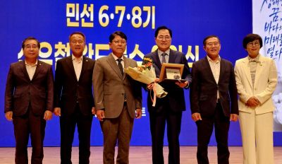 신우철 군수에게 공로패를 전달하며 12년의 헌신에 감사를 표하는 완도군의회 의원들. 이준경 기자