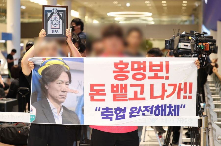 2026 북중미 월드컵 32강 진출에 실패해 한국 축구 국가대표팀에서 사퇴한 홍명보 전 감독이 입국하는 30일 인천국제공항 제2여객터미널을 찾은 팬들이 항의 현수막을 들어올리고 있다.