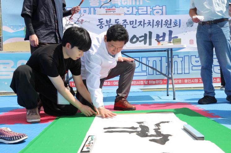 이상일 용인특례시장이 11일 용인특례시 주민자치박람회에서 서예 작품에 손도장을 찍고 있다. 용인시 제공