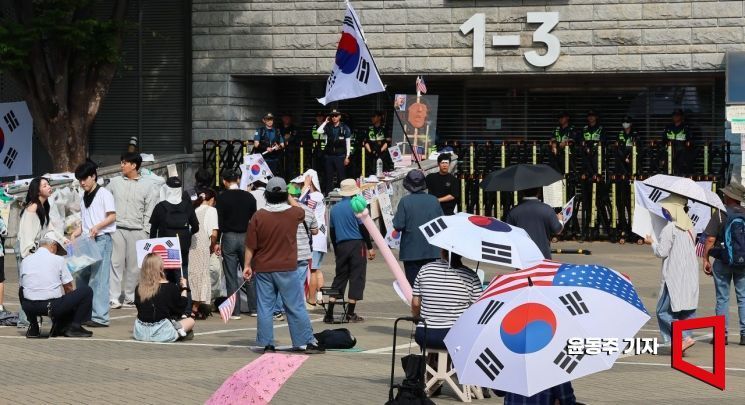 ‘개표소 봉쇄 시위’가 이어지고 있는 지난달 17일 서울 송파구 올림픽공원 핸드볼경기장 출입구에서 시위대가 성조기와 태극기를 흔들고 있다. 윤동주 기자