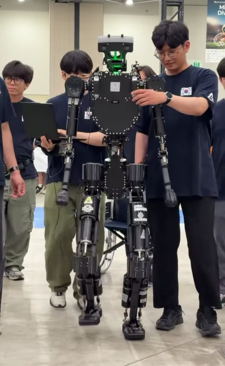 한양대·에이로봇 팀원들이 로보컵 2026 기간 중 앨리스5 로봇을 보행시키고 있다. 지난 5월 조립이 완료된 앨리스5는 대회 기간에도 학습을 이어가며 보행 성능이 크게 향상됐다. 사진=엄윤설 에이로봇 대표 페이스북