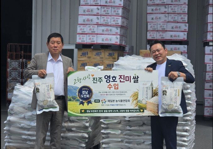 재일경남도민회가 경남 진주에서 생산된 경남도 대표 쌀 품종 '영호진미'를 들어 보이며 일본 수출을 알리고 있다. [사진제공=경남도]