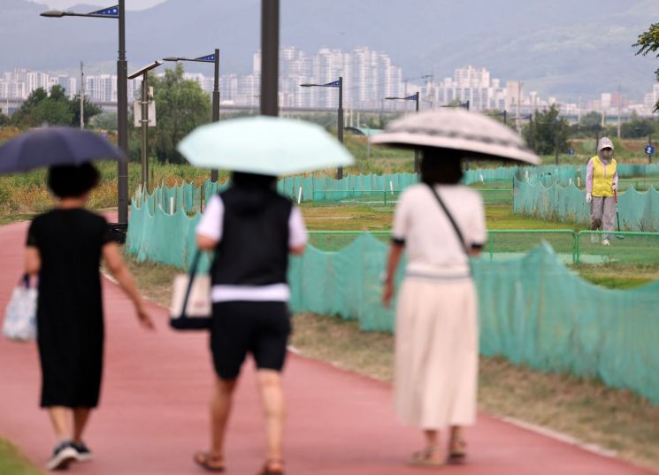 경북 경산시 남천 둔치에서 시민들이 양산을 쓰고 산책하고 있다. 연합뉴스