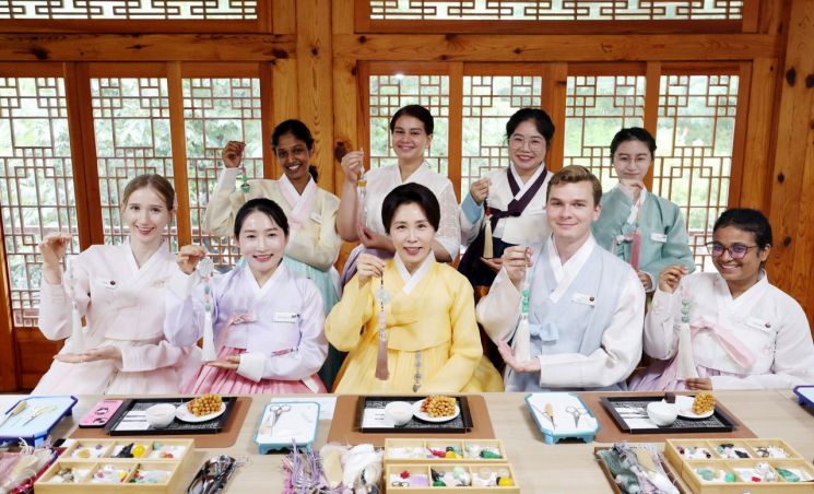 김혜경 여사가 20일 서울 종로구 부암동 무계원 사랑채에서 외국인 청년들과 직접 만든 한국 전통공예 노리개를 들고 기념촬영을 하고 있다. 2026.7.20 [청와대통신사진기자단] 연합뉴스