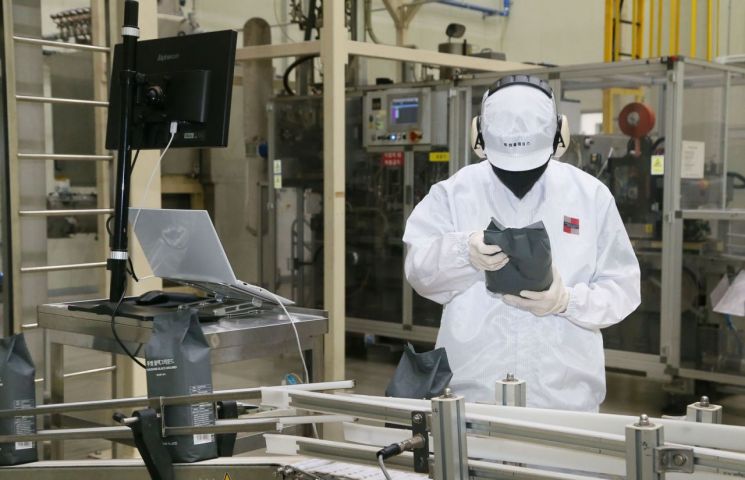22일 충북 음성 투썸플레이스의 커피·디저트 전문 생산 시설인 어썸 페어링 플랜트 내부 포장 설비 앞에서 직원이 포장된 원두를 확인하고 있다. 투썸플레이스 제공