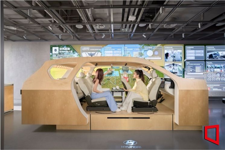 UX 스튜디오 상하이 내 UX 테스트 존에 전시된 나무로 만든 스터디 벅에서 방문객들이 마주 앉아 대면 모드를 체험하고 있다. 현대차