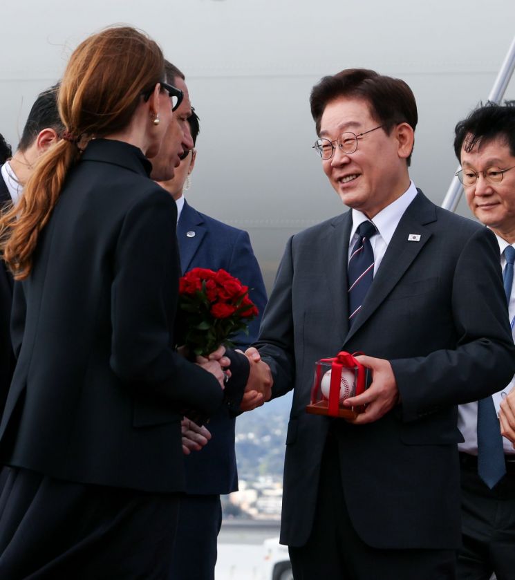 미국 샌프란시스코를 방문한 이재명 대통령이 24일(현지시간) 샌프란시스코 국제공항에서 영접 나온 다니엘 루리 샌프란시스코 시장으로부터 야구공을 선물 받은 뒤 이야기를 나누고 있다. 2026.7.25 연합뉴스