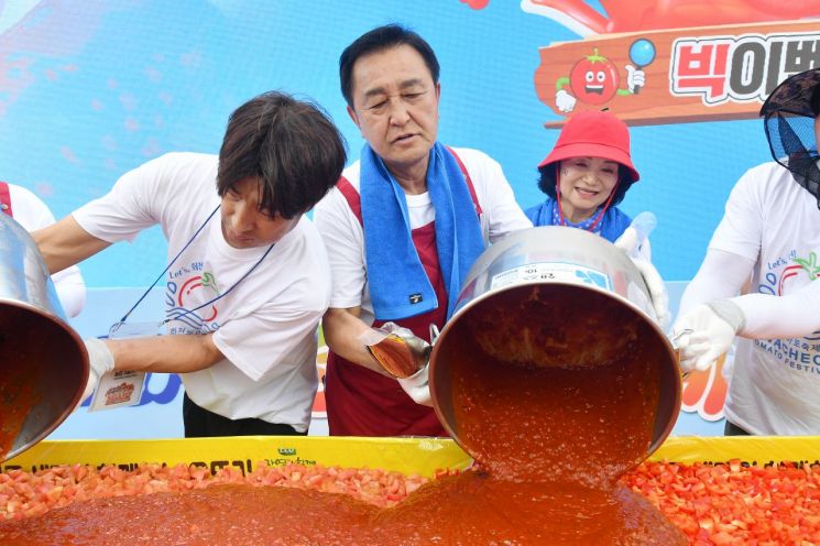 김세훈 화천군수가 2026 화천토마토축제에 토마토를 넣고 있다.  화천군 제공