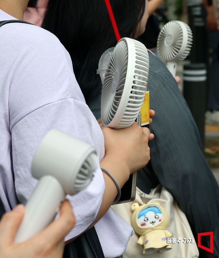 서울 전역과 경기, 호남 등 서쪽 지역을 중심으로 40도에 육박하는 폭염중대경보가 발효된 지난 5일 서울역 주변으로 출근길에 오른 시민들 손에 선풍기가 들려있다. 있다.