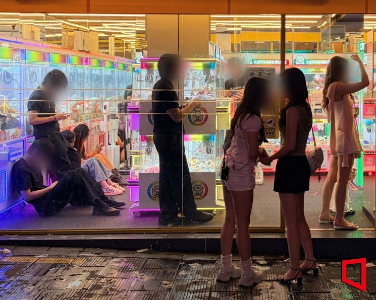 지난 14일 밤 서울 용산구 한 무인점포에서 취객들이 매장 내부를 차지하거나 입구에서 담배를 피우면서 사실상 방치된 모습을 보이고 있다. 이지예 기자