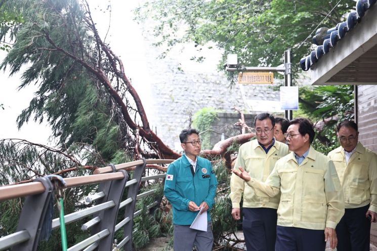 박완수 경남도지사(오른쪽 가장 앞)가 통영 용화사 입구의 집중호우 피해 상황을 보며 복구 작업 진행에 대해 지시하고 있다. [사진제공=경남도]