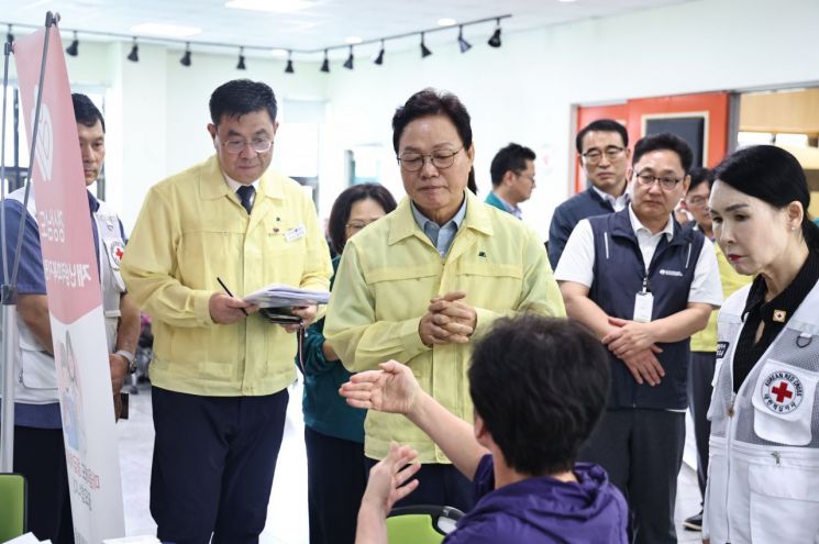 박완수 경남도지사(가운데)가 거제 옥포종합사회복지관에 마련된 이재민 대피소에서 이재민의 이야기를 들으며 대피소 내 숙식 및 의료, 생활지원 상황 등을 점검하고 있다. [사진제공=경남도]