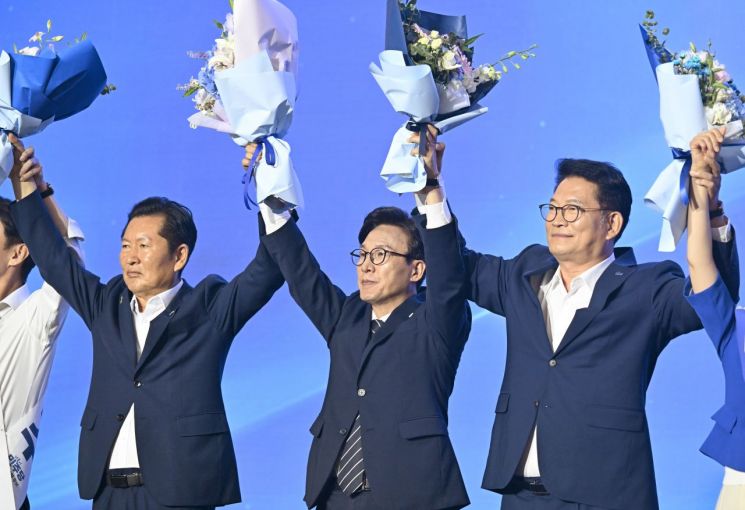 더불어민주당 김민석 신임 당 대표가 17일 대전 컨벤션센터에서 열린 제3회 더불어민주당 정기 전국당원대회에서 당 대표로 선출된 뒤 정청래(왼쪽), 송영길 후보와 함께 당원들에게 인사하고 있다. 2026.8.17 [공동취재] 연합뉴스