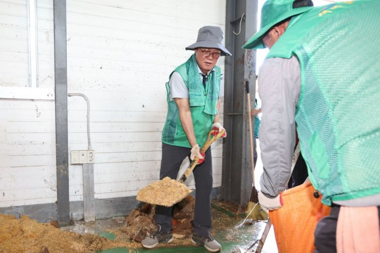 박완수 경남도지사가 극한호우로 거제시 연초면 연초농협 자재센터에 쓸려간 토사를 삽으로 퍼내고 있다. [사진제공=경남도]