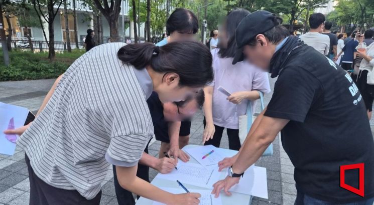 19일 오후 6시30분께 서울 용산구 용산어린이정원 정문 앞 한마음공원에서 시민들이 용산공원 부지 내 주택공급 반대를 위한 서명을 하고 있다. 심성아 기자