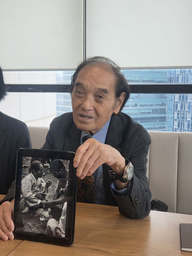 구와바라 시세이가 1965년 찍은 베트남 파병 열차 사진을 보여주며 어머니와 작별 인사를 나누던 군인을 그리워하고 있다./이종길 기자.