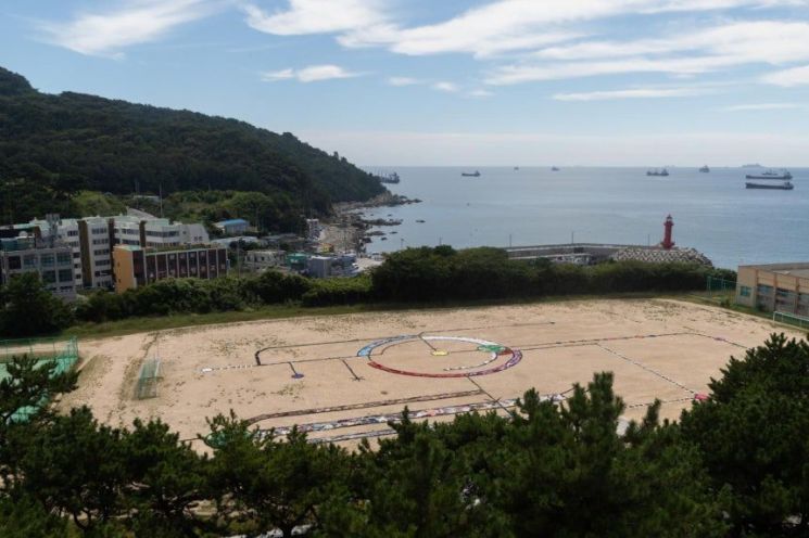 이란 출신 영국 작가 알리아스카르 아바카스가 지역 주민들과 함께 재활용 직물을 이어 옛 부산남고 운동장에 완성한 작품 '주문'. 거대한 악보를 연상시키는 형태에 보호와 안녕을 기원하는 의미를 담았다. 부산비엔날레