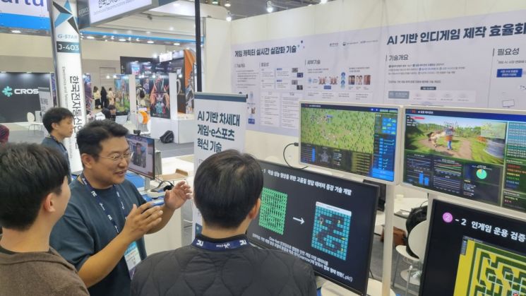 ETRI 연구원들이 전시 부스 현장에서 'AI 기반 게임 제작검증 자동화 플랫폼'을 시연하고 있다. 한국전자통신연구원
