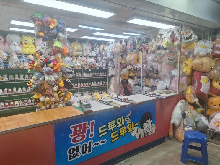 황재복 회장의 곁에서 풍선 맞추기 게임존을 30여 년 지켜온 아내가 손님이 없는 틈에 깜빡 졸고 있다. 사진=최대억 기자