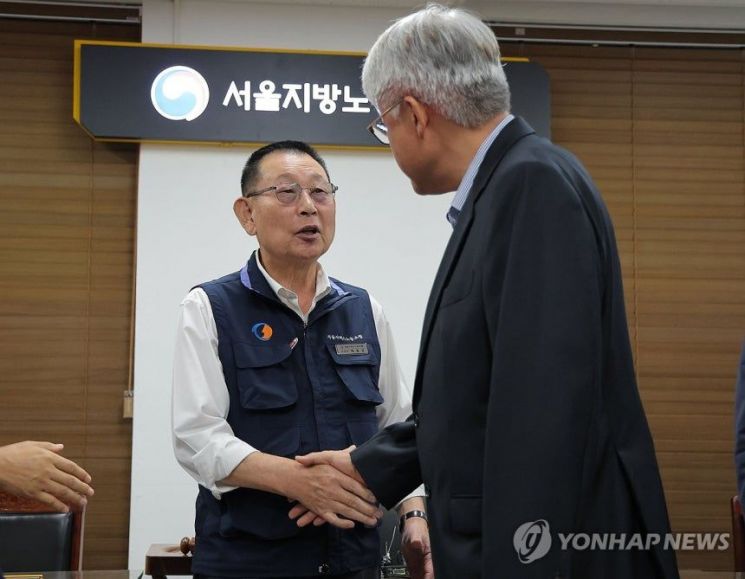 16일 서울 영등포구 서울지방노동위원회에서 열린 버스노조의 노동 쟁의 관련 분쟁에 대한 조정 회의에서 김정환 서울시버스운송조합 이사장과 박점곤 서울시버스노조 위원장이 조정안에 서명한 뒤 인사를 나누고 있다. 연합뉴스