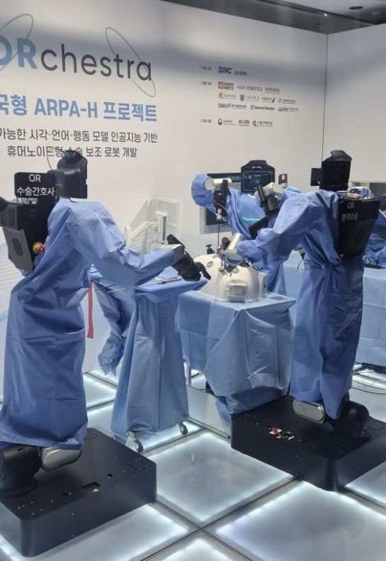 16일 서울 강남구 삼성생명 일원역빌딩에서 열린 삼성서울병원 '휴머노이드형 수술보조로봇 공개 시연'에서 휴머노이드 로봇 3대가 수술 모사 장치를 둘러싸고 원격 집도 시연을 하고 있다. 수술 가운을 입은 로봇들은 등에 붙인 표시에 따라 수술간호사(왼쪽), 내시경·견인 보조(가운데), 원격 수술 집도(오른쪽)를 각각 맡았다. 박정연 기자