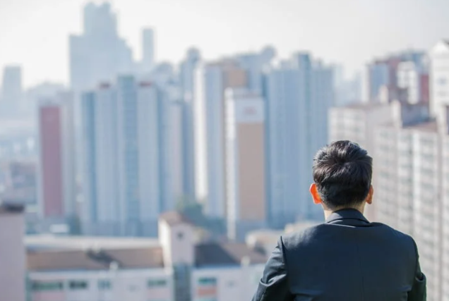 아파트를 바라보고 있는 직장인. 게티 이미지