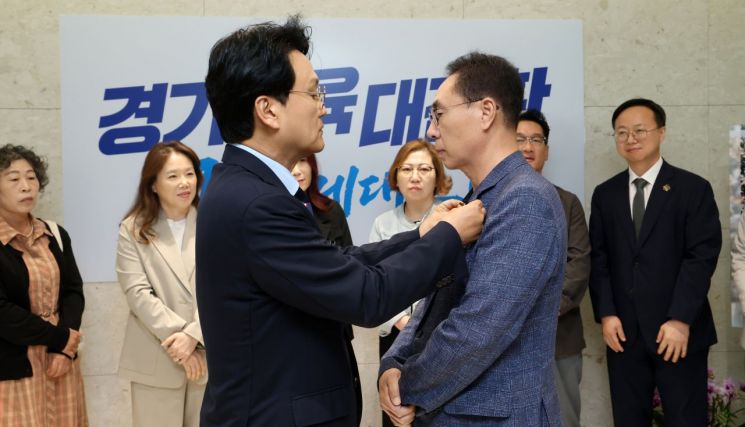 안민석 경기도교육감이 18일 조례안 의결 직후 교권 보호의 최일선에서 활동하는 교권보호전담관에게 책임과 사명을 상징하는 배지를 수여하고 있다. 경기도교육청 제공