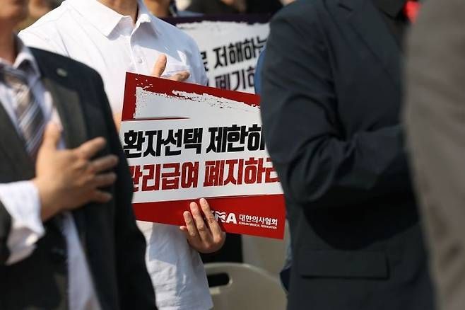 대한의사협회가 지난 6월 28일 서울 중구 대한문 앞에서 대한정형외과의사회, 대한신경외과의사회, 대한마취통증의학과의사회, 대한재활의학과의사회 등과 함께 연 도수치료 관리급여 전환 반대 궐기대회에서 참가자들이 구호를 외치고 있다. 연합뉴스