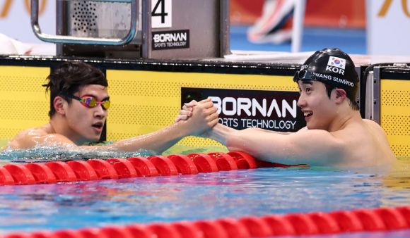 황선우(오른쪽)가 20일 도쿄 아쿠아틱스 센터에서 열린 2026 아이치·나고야 아시안게임 수영 남자 100m 자유형 결승에서 3위를 차지한 뒤 금메달을 딴 판잔러와 악수하고 있다. 도쿄=연합뉴스