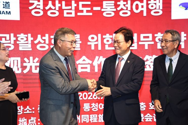 박완수 경남도지사(오른쪽)가 중국 여행플랫폼 '통청여행' 본사 관계자와 업무협약을 맺고 악수를 나누고 있다. [사진제공=경남도]
